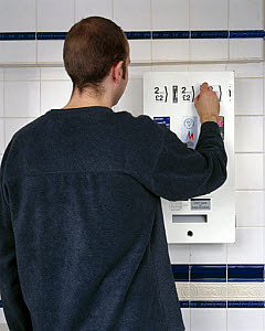 10324389
&copy; Science Museum
Man buying condoms from a vending machine, December 2000.