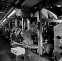 10414879
&copy; NMeM - Walter Nurnberg
Man at gate of printing machine inspecting newspapers, Bolton, 1962.