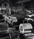 10416358
&copy; NMeM - Walter Nurnberg
A worker examines finished rolls of aluminium sheets on production line.