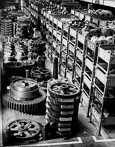10416523
&copy; NMeM - Walter Nurnberg
Long shot of storeman with large cogs  stacked, Ransome and Rapier, 1959.