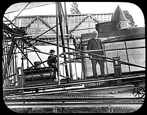 10423897
&copy; Science Museum
Maxim standing on the framing of his 1894 machine outside the hangar, 1894.