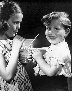 10327126
Children sharing a drink, 1940s.