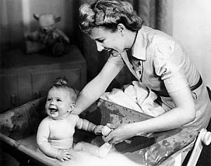 10327127
Woman bathing a baby, 1940s.