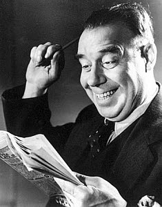 10327132
Smiling man reading a newspaper, c 1940s.