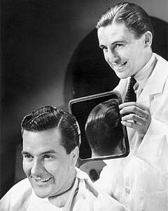 10327133
Man inspecting the back of his new haircut in a barber�s mirror, c 1940s.