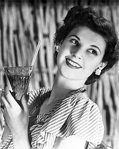 10327048
Smiling young woman holding a drink, c 1940s.
