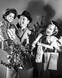 10327148
Family carrying Christmas decorations and parcels, 1940s.