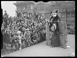 10461365
&copy; NMeM Daily Herald Archive
Father Christmas arrives at Selfridges by parcel post, with Mickey Mouse, 1935.