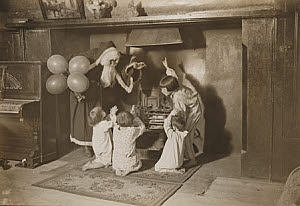 10461386
&copy; NMeM Daily Herald Archive
Father Christmas and children round a fireplace, 3 December 1932.