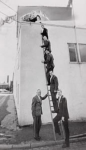 10309086
Car salesmen standing on a ladder, 5 August 1966.