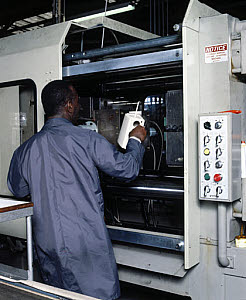 10284218
&copy; Science Museum
Removing plastic kettle body from an injection moulding machine, c 1985.