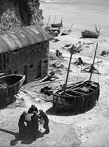 10309725
&copy; NMeM - Kodak Collection
Four fishermen talking near small fishing b