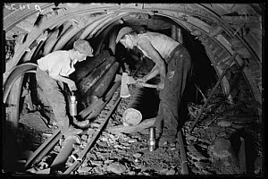 10440877
&copy; NMeM Daily Herald Archive
Underground repairman and child cutting timber in a mine, 1931.